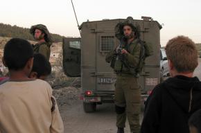 Israel Defense Force soldiers interrogate a group of Palestinian children on the outskirts of Hebron